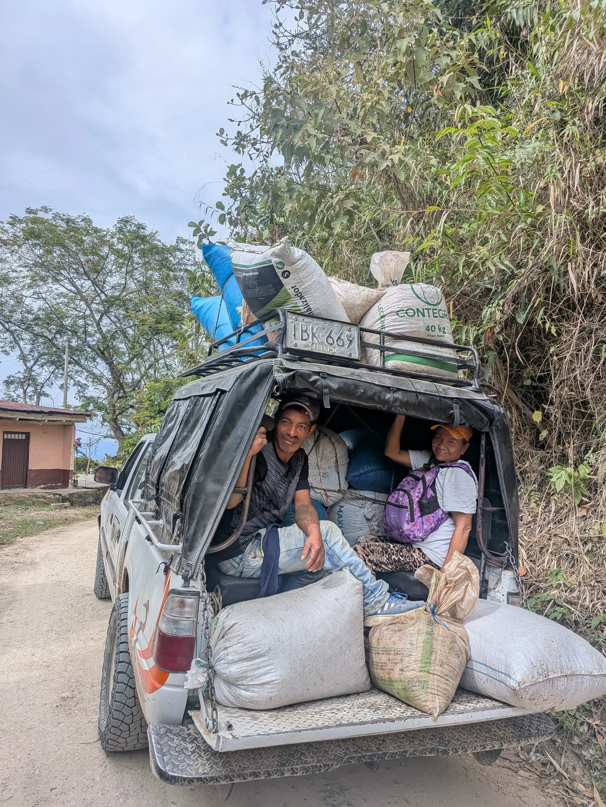 Coffee farmers carrying sacks of coffee cherries on the road down toward Agrado