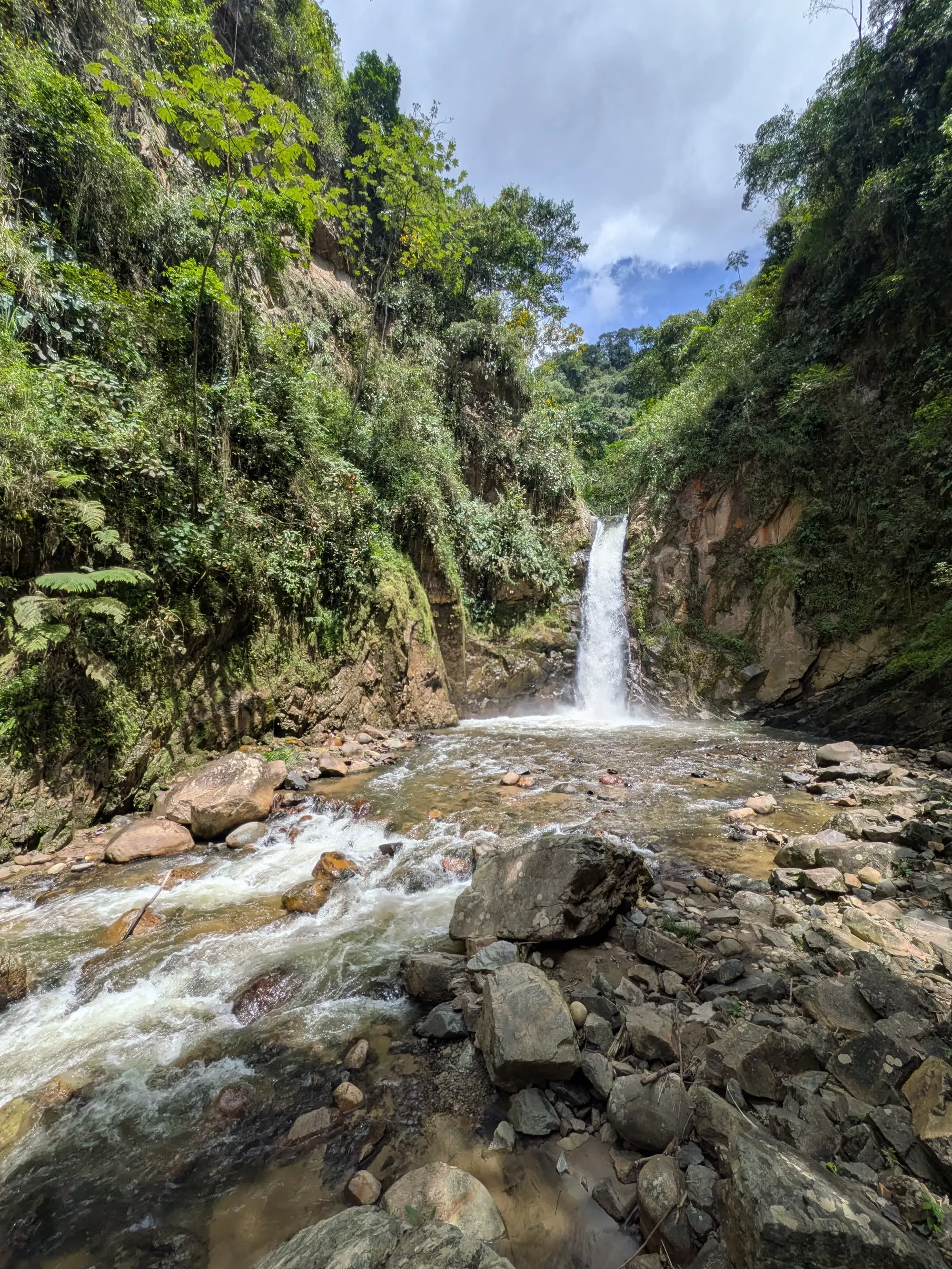 Cascada las Damas erupting from the forest into a narrow canyon